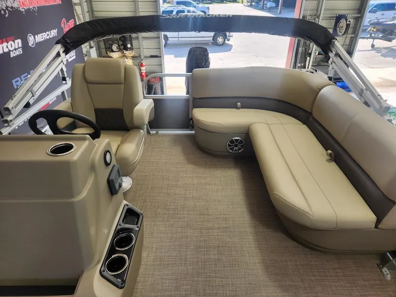 Slide: The Image of 2025 Sun Tracker PARTY BARGE® 16 DLX interior with beige seating and steering console. - 8