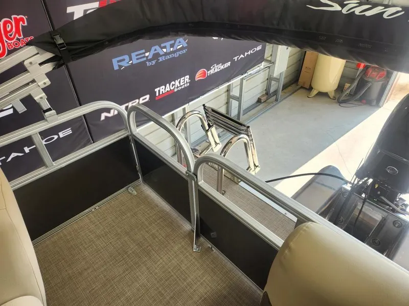 Slide: The Image of 2025 Sun Tracker PARTY BARGE® 16 DLX interior with seating and railing in showroom. - 9