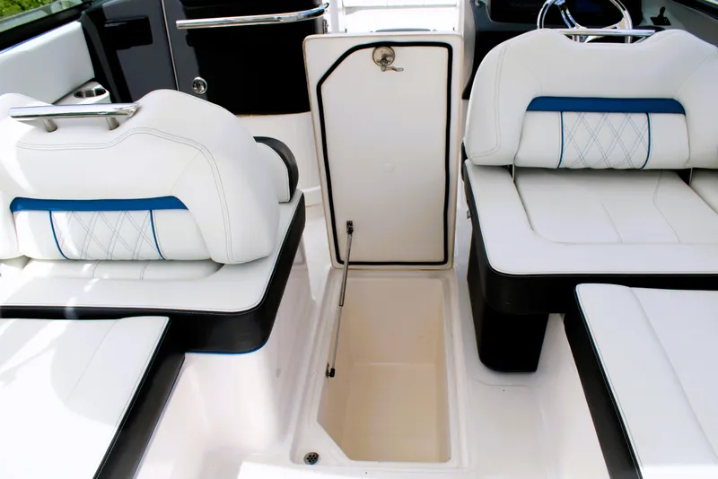 Slide: The Image of 2023 Regal LX6 boat interior with white seating and storage compartment. - 28