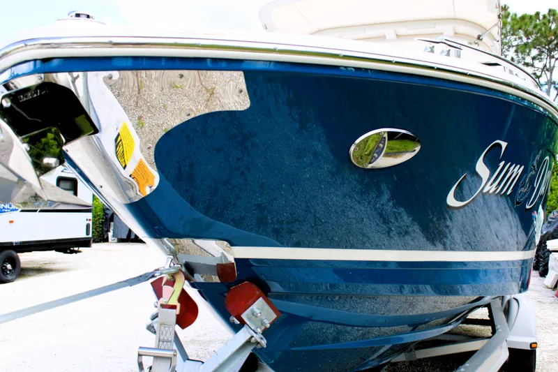 Slide: The Image of 2023 Regal LX6 boat on trailer, blue hull, close-up view. - 4