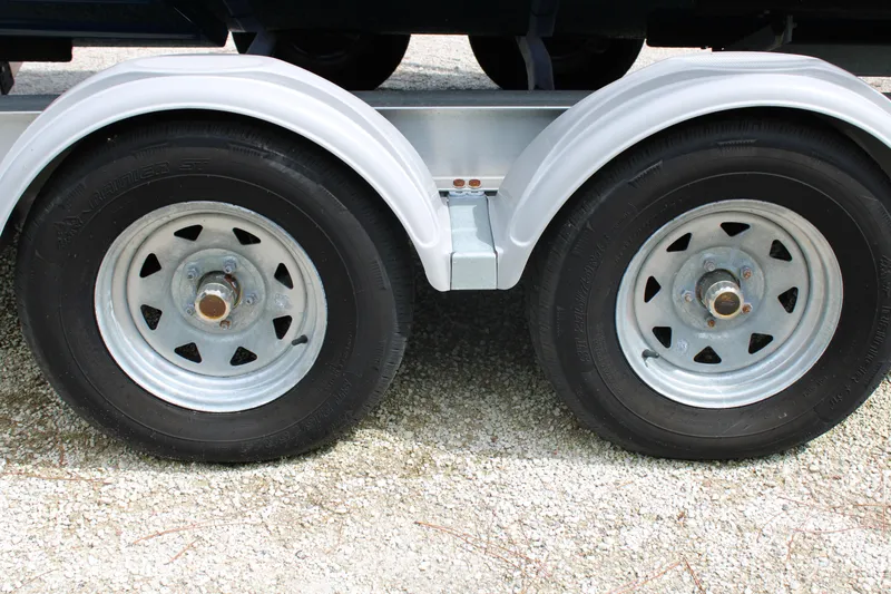 Slide: The Image of Close-up of 2023 Regal LX6 trailer wheels on gravel surface. - 9