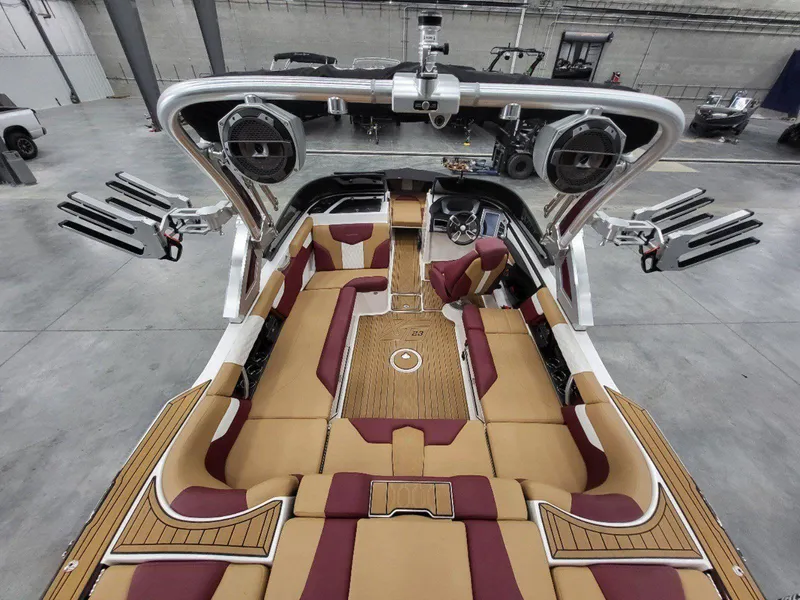 Slide: The Image of 2022 MasterCraft XT23 boat interior with tan and burgundy seating, spacious layout, and modern design. - 13