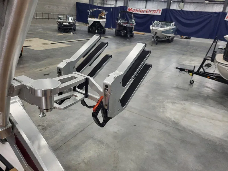 Slide: The Image of 2022 MasterCraft XT23 boat rack in showroom with other boats in background. - 15