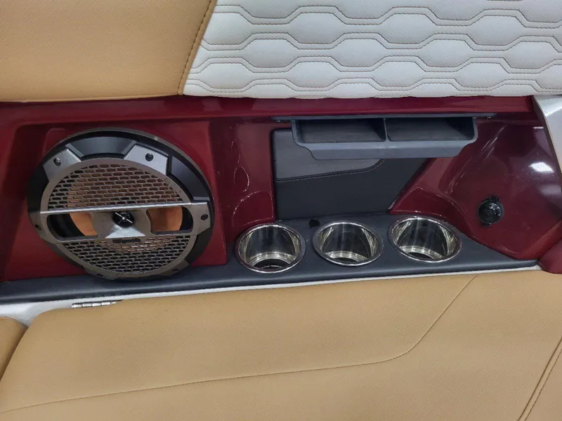 Slide: The Image of 2022 MasterCraft XT23 interior with speaker, cup holders, and beige upholstery. - 26