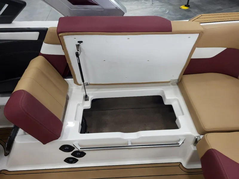 Slide: The Image of 2022 MasterCraft XT23 boat interior with open storage compartment and cushioned seating. - 28