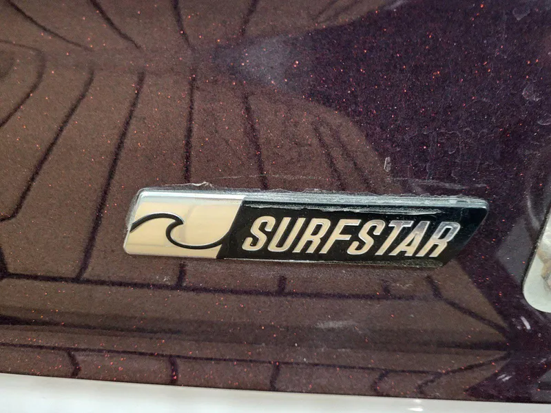 Slide: The Image of 2022 MasterCraft XT23 SurfStar logo on a metallic brown surface. - 33