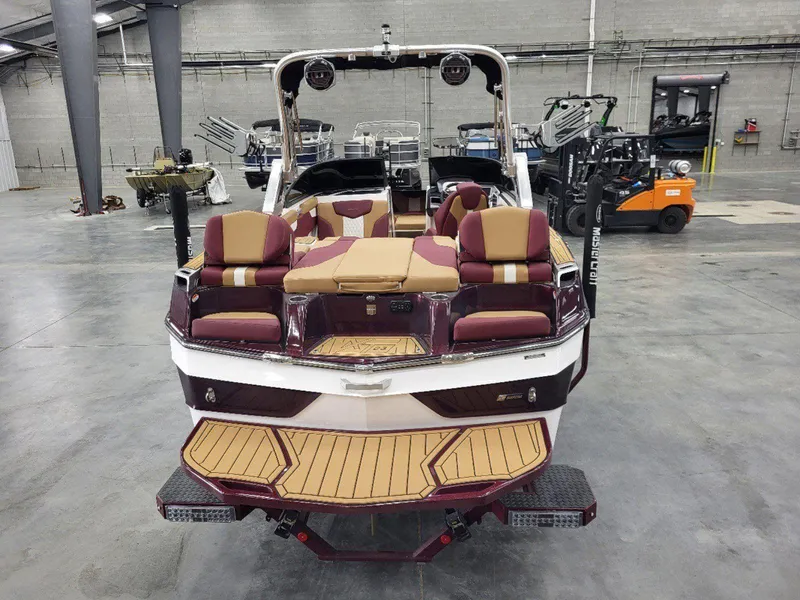 Slide: The Image of 2022 MasterCraft XT23 boat with maroon and tan interior in a warehouse setting. - 4