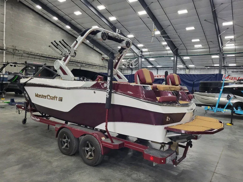 Slide: The Image of 2022 MasterCraft XT23 boat in showroom, featuring sleek design and vibrant colors. - 6