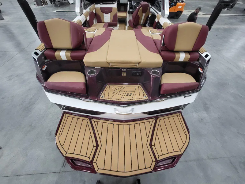Slide: The Image of 2022 MasterCraft XT23 boat interior with tan and maroon seating, spacious layout. - 9