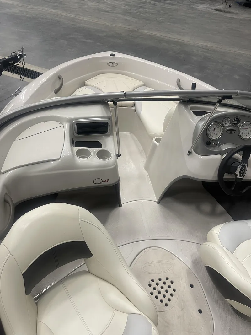 Slide: The Image of 2010 Tracker TAHOE Q4 boat interior with white seating and dashboard controls. - 9