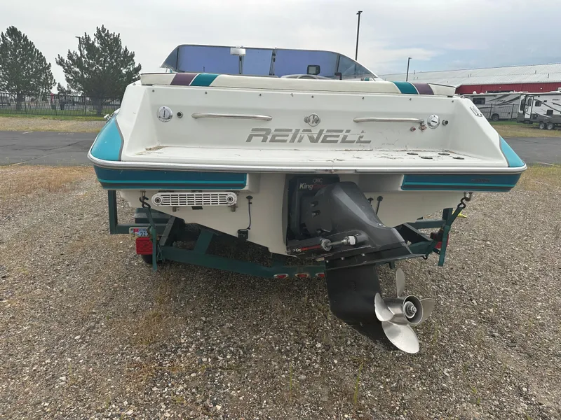 Slide: The Image of 1993 REINELL 2400RXL boat rear view with propeller, parked on gravel. - 4