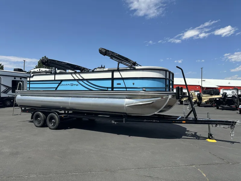Slide: The Image of 2023 Forest River SOUTH BAY 224FCR pontoon boat on trailer, parked outdoors. - 5