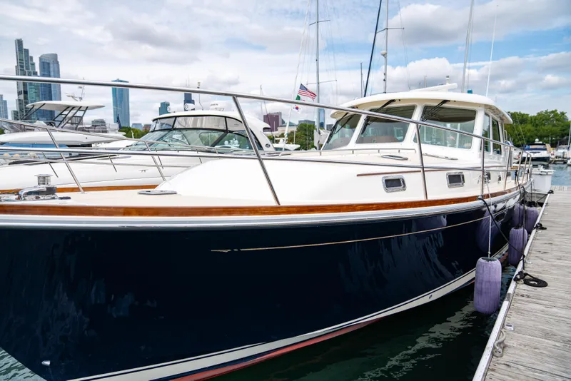 Slide: The Image of 2015 Sabre 48 Salon Express yacht docked in marina, city skyline in background. - 0
