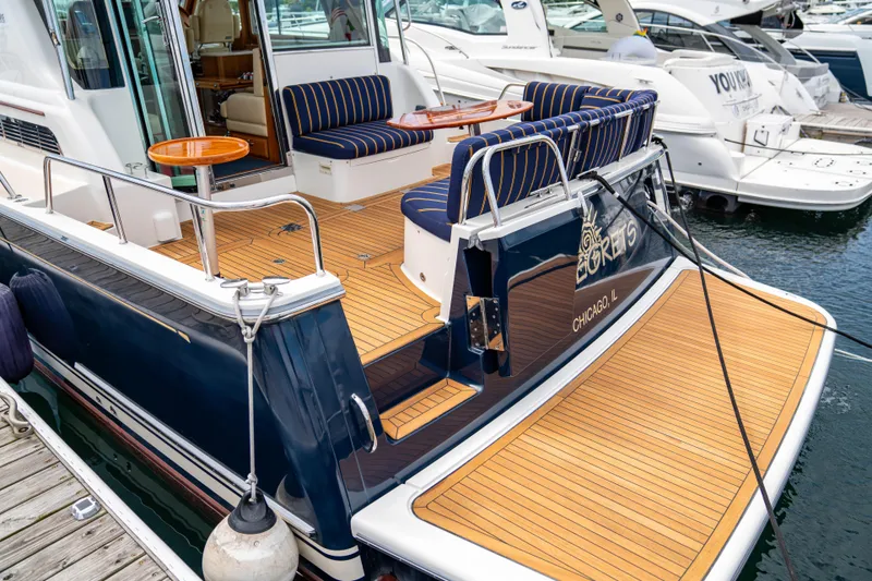 Slide: The Image of 2015 Sabre 48 Salon Express yacht with teak deck and striped seating at marina. - 10