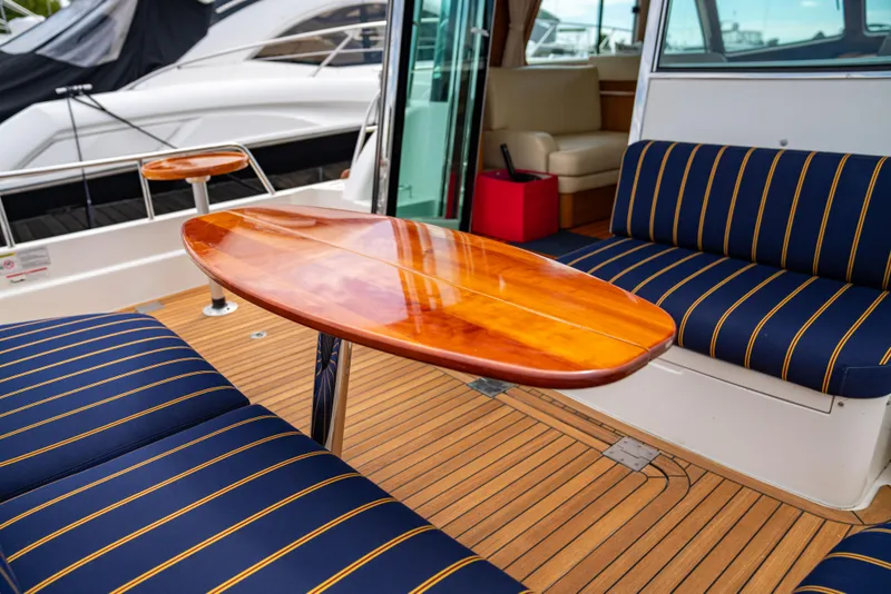Slide: The Image of Interior of 2015 Sabre 48 Salon Express with wooden table and striped seating. - 11