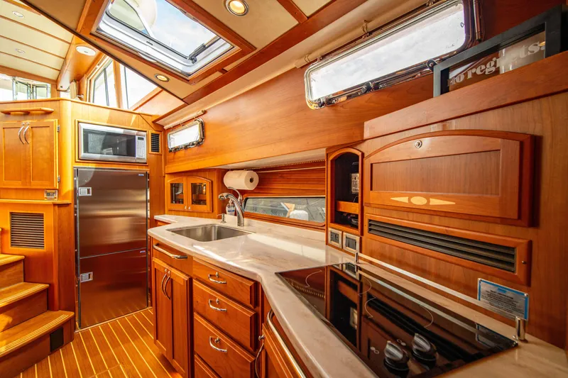 Slide: The Image of Luxurious 2015 Sabre 48 Salon Express yacht kitchen with wood cabinetry and modern appliances. - 17