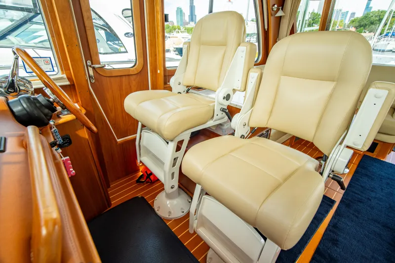 Slide: The Image of 2015 Sabre 48 Salon Express interior with beige captain chairs and wooden accents. - 23