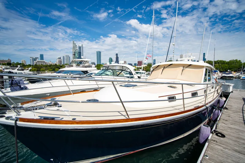 Slide: The Image of 2015 Sabre 48 Salon Express yacht docked in marina, city skyline in background. - 25