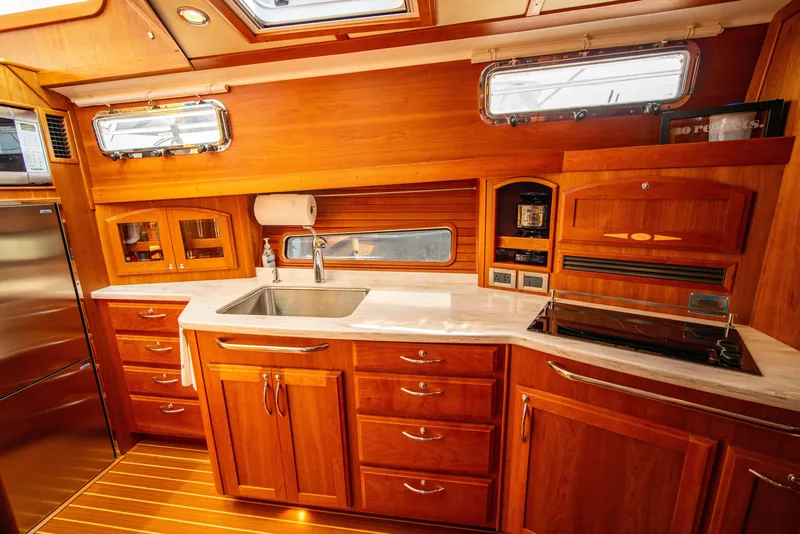 Slide: The Image of Luxurious 2015 Sabre 48 Salon Express yacht kitchen with wooden cabinetry and modern appliances. - 30