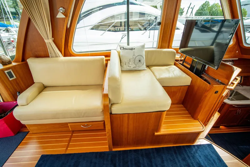 Slide: The Image of Interior of 2015 Sabre 48 Salon Express with beige seating and TV. - 6