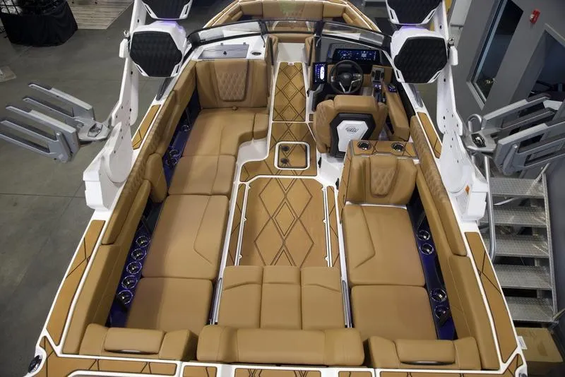Slide: The Image of 2025 Malibu M242 boat interior with luxurious tan seating and modern dashboard. - 12