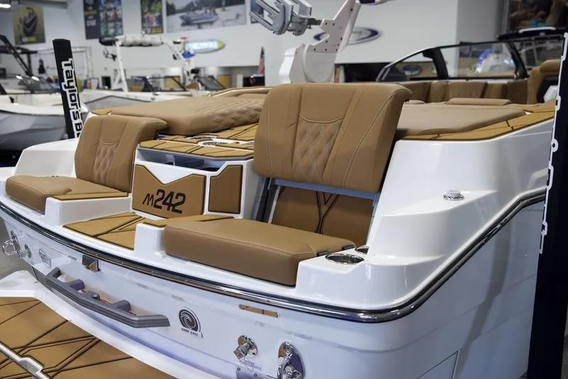 Slide: The Image of 2025 Malibu M242 boat with luxurious tan seating and sleek design. - 13