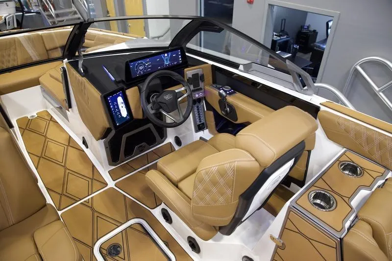 Slide: The Image of 2025 Malibu M242 boat interior with tan leather seats and modern dashboard. - 16