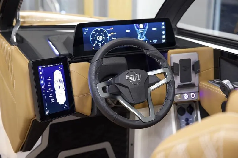 Slide: The Image of 2025 Malibu M242 boat dashboard with digital displays and modern steering wheel. - 17