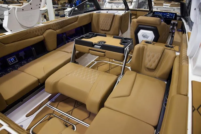 Slide: The Image of Luxurious interior of 2025 Malibu M242 boat with tan leather seating and modern amenities. - 23