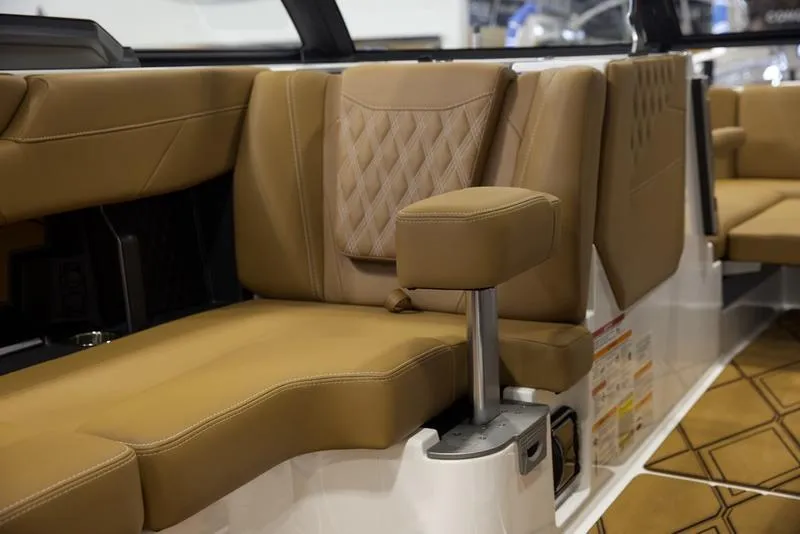 Slide: The Image of 2025 Malibu M242 boat interior with tan leather seating and armrest. - 35