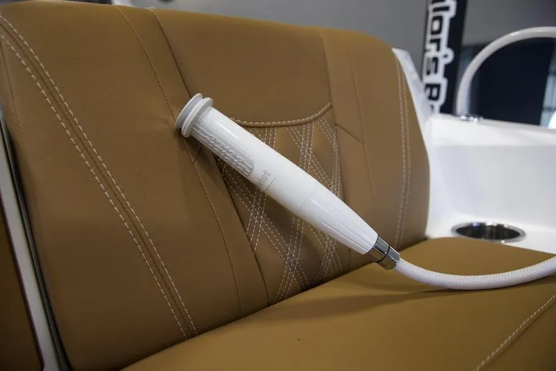 Slide: The Image of 2025 Malibu M242 boat interior with tan leather seating and white handle detail. - 37