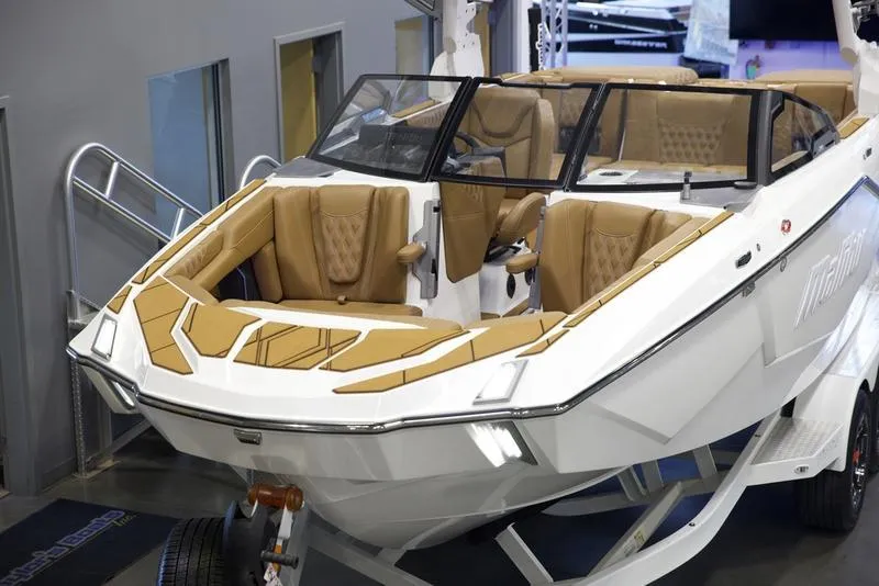 Slide: The Image of 2025 Malibu M242 boat with luxurious tan seating and sleek design. - 9