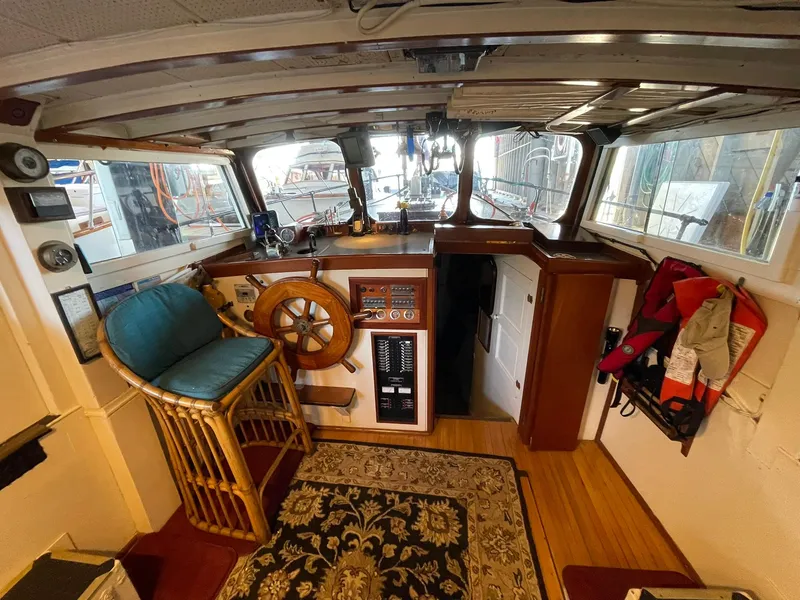Slide: The Image of 1940 Historic Tacoma Boat Co Cruiser interior with wooden helm, vintage controls, and nautical decor. - 1