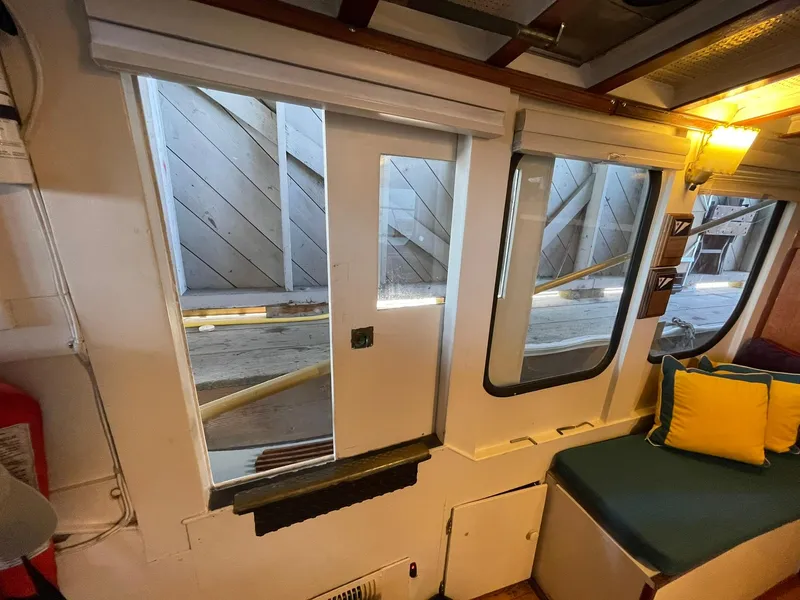 Slide: The Image of Interior of a 1940 Historic Tacoma Boat Co Cruiser with cozy seating and large windows. - 16