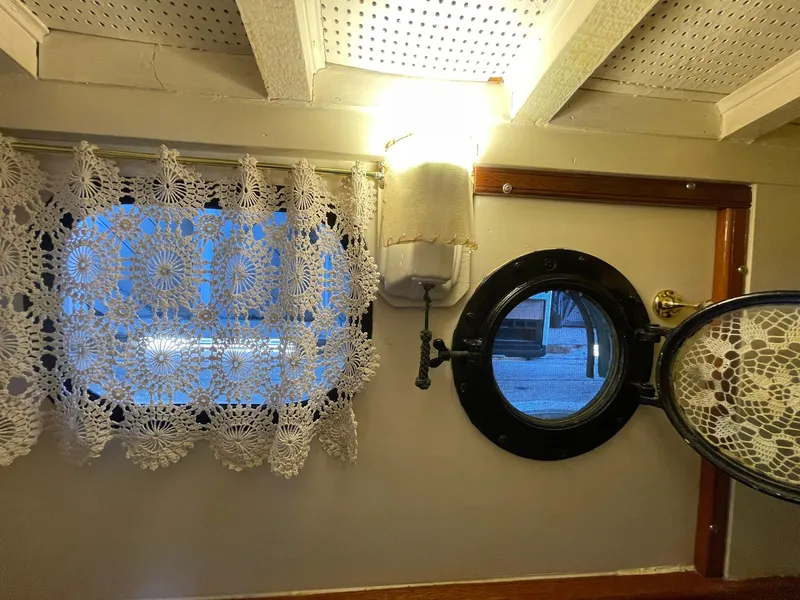 Slide: The Image of 1940 Historic Tacoma Boat Co Cruiser interior with lace curtains and porthole. - 33