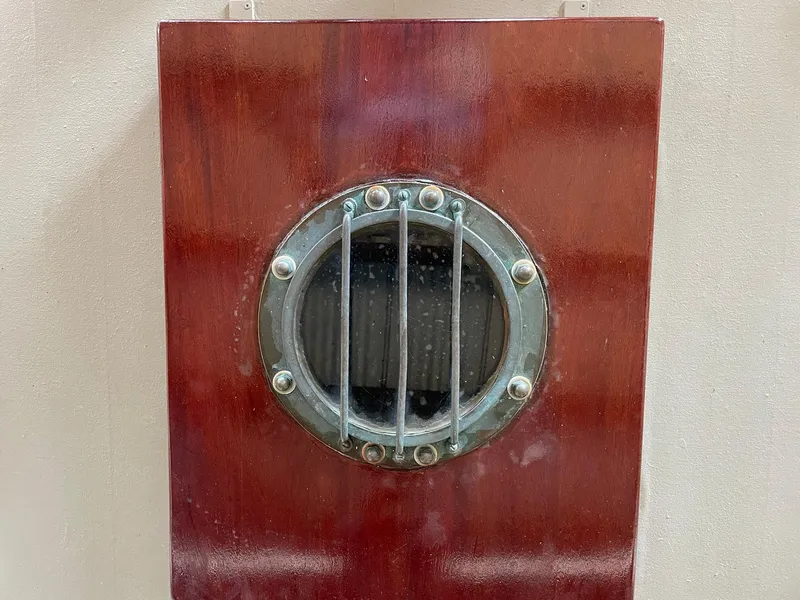 Slide: The Image of 1940 Historic Tacoma Boat Co Cruiser porthole on polished wood panel. - 43