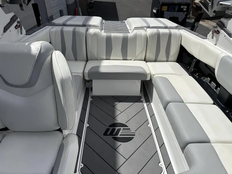 Slide: The Image of 2023 Malibu 22 LSV boat interior with white and gray seating. - 2