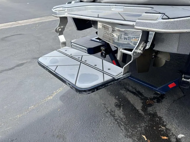 Slide: The Image of 2023 Malibu 22 LSV swim platform with power wedge on a paved surface. - 3
