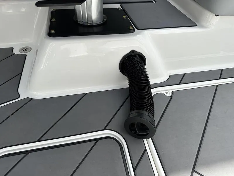 Slide: The Image of 2023 Malibu 22 LSV boat deck with black hose and gray flooring. - 9