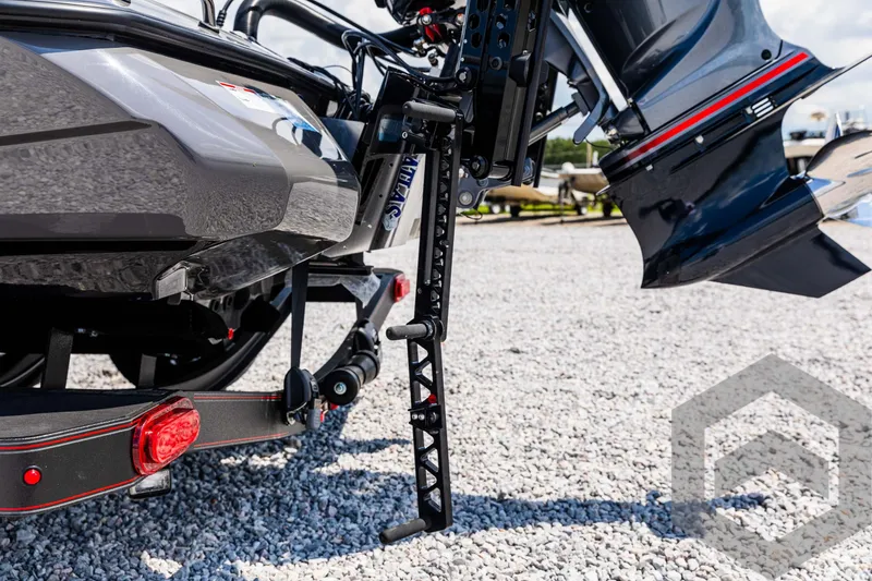 Slide: The Image of 2025 Skeeter ZXR 21 boat trailer detail with motor and gravel background. - 20