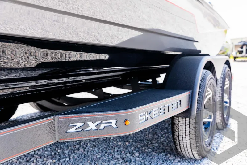Slide: The Image of 2025 Skeeter ZXR 21 boat trailer with dual wheels on gravel. - 25