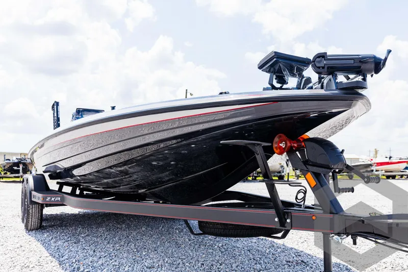 Slide: The Image of 2025 Skeeter ZXR 21 boat on trailer, sleek design, parked on gravel. - 9