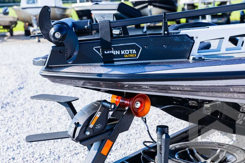 Slide: The Image of 2025 Skeeter ZXR 20 boat with Minn Kota Ultrex trolling motor, parked on gravel. - 23