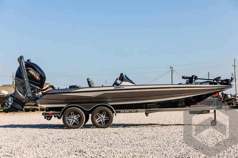 Slide: The Image of 2025 Skeeter ZXR 20 boat on trailer, parked on gravel lot. - 4