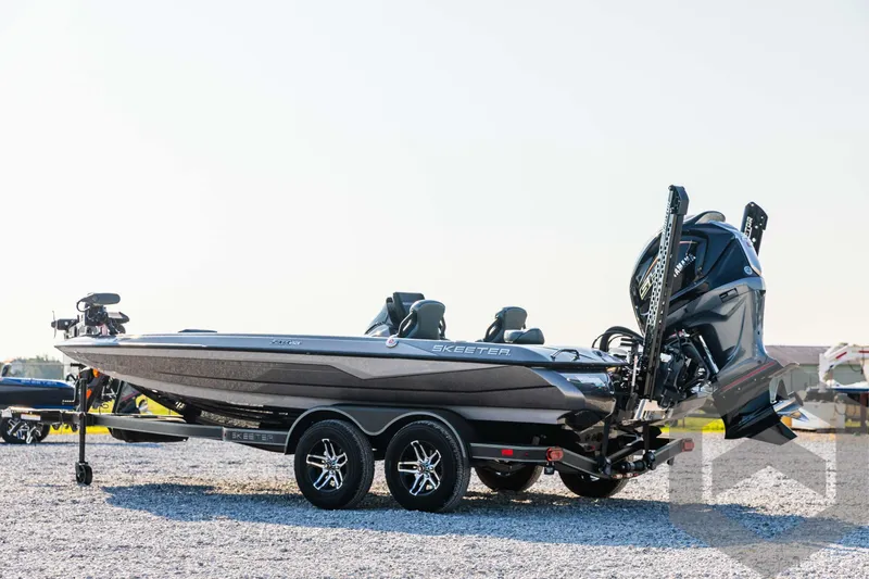 Slide: The Image of 2025 Skeeter ZXR 20 bass boat with dual motors on a gravel lot. - 7
