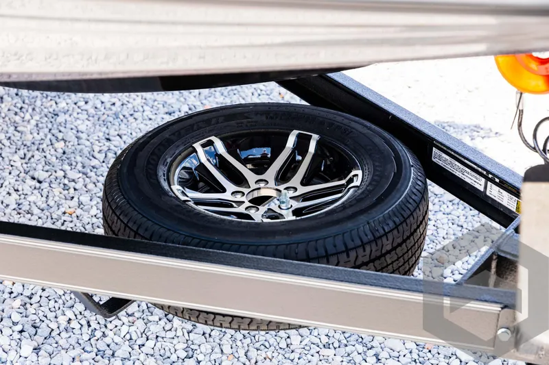 Slide: The Image of 2025 Skeeter ZXR 20 trailer with spare tire on gravel surface. - 11