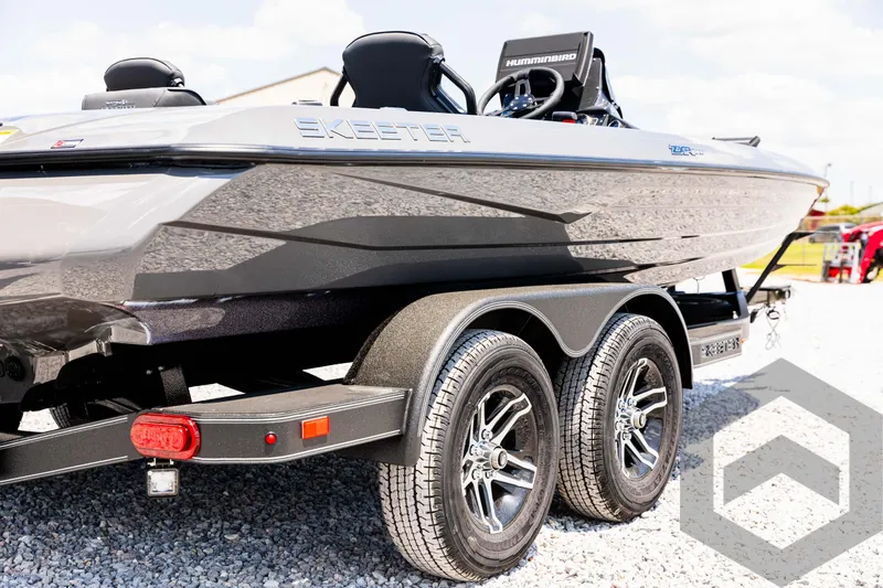 Slide: The Image of 2025 Skeeter ZXR 20 boat on trailer, sleek design, dual axles, outdoor setting. - 14