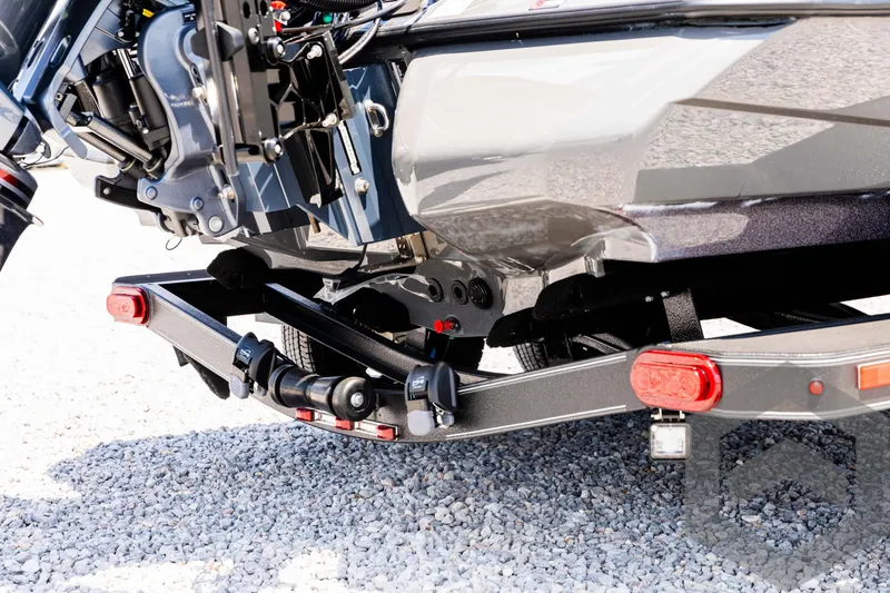 Slide: The Image of 2025 Skeeter ZXR 20 boat trailer detail on gravel surface. - 15