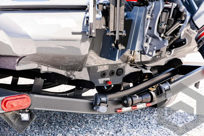 Slide: The Image of 2025 Skeeter ZXR 20 boat trailer detail with engine components and gravel background. - 19