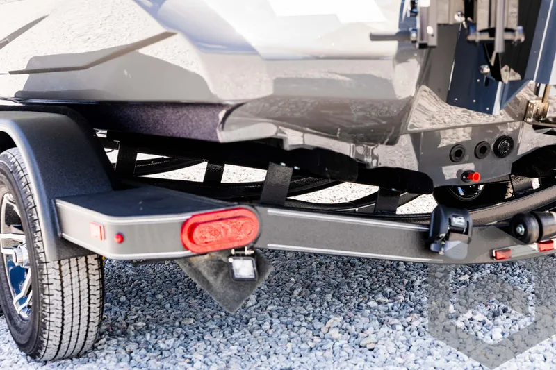 Slide: The Image of 2025 Skeeter ZXR 20 boat trailer, rear view, on gravel surface. - 20